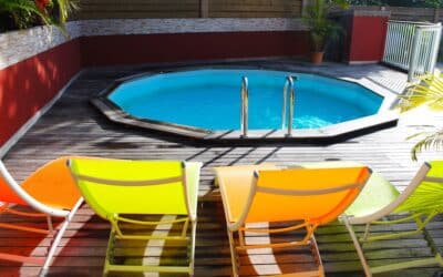 a pool with a hot tub and chairs around it