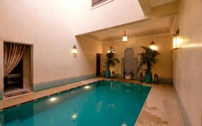 Elegant indoor pool in a Marrakesh riad, showcasing traditional Moroccan architecture and decor.